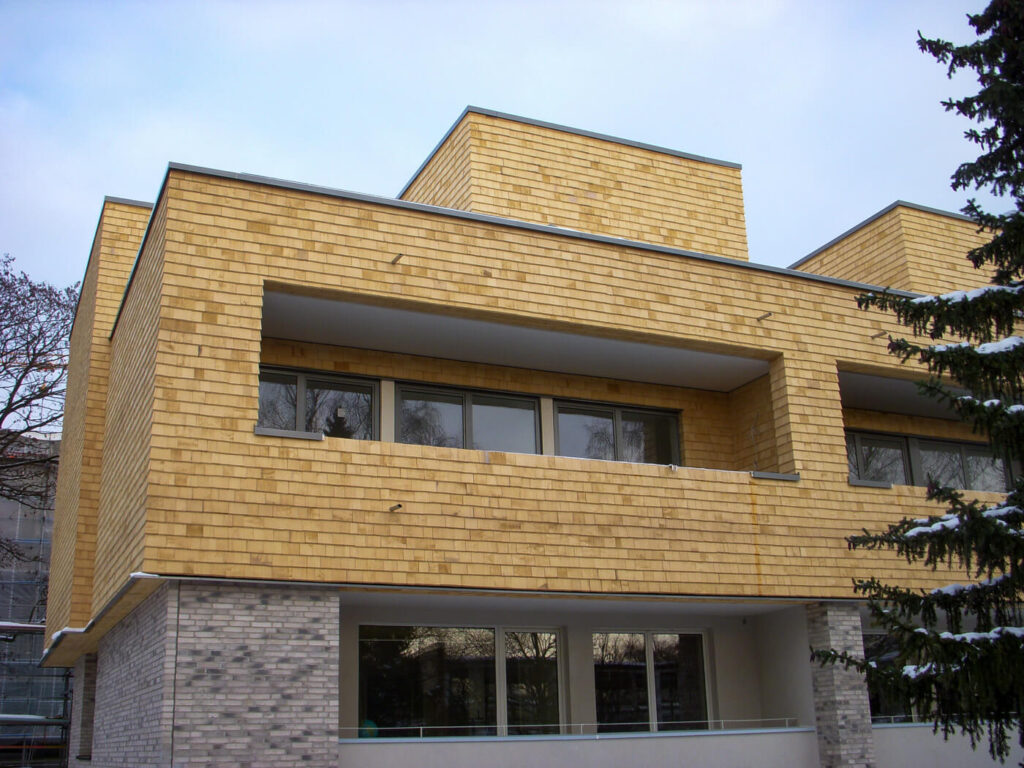 Hausfassade mit Holzschindeln aus Alaska Zeder gesaegt