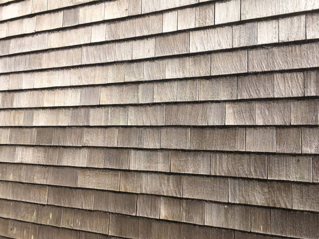 Hausfassade mit Holzschindeln aus Rot Zeder gesgaegt
