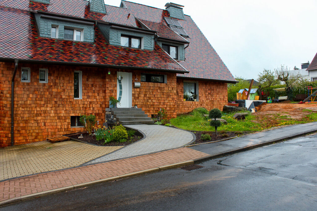 Hausfassade mit Holzschindeln aus Rot Zeder gesgaegt