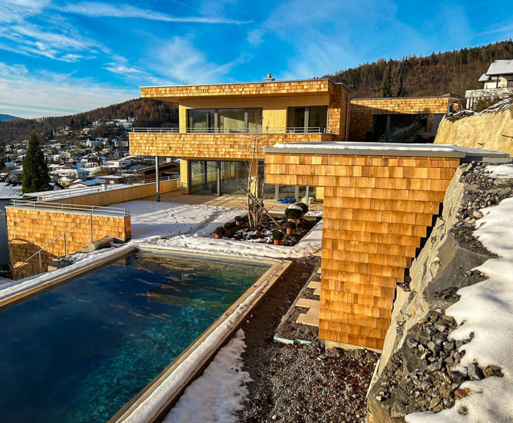 Hausfassade mit Holzschindeln aus Rot Zeder gesgaegt