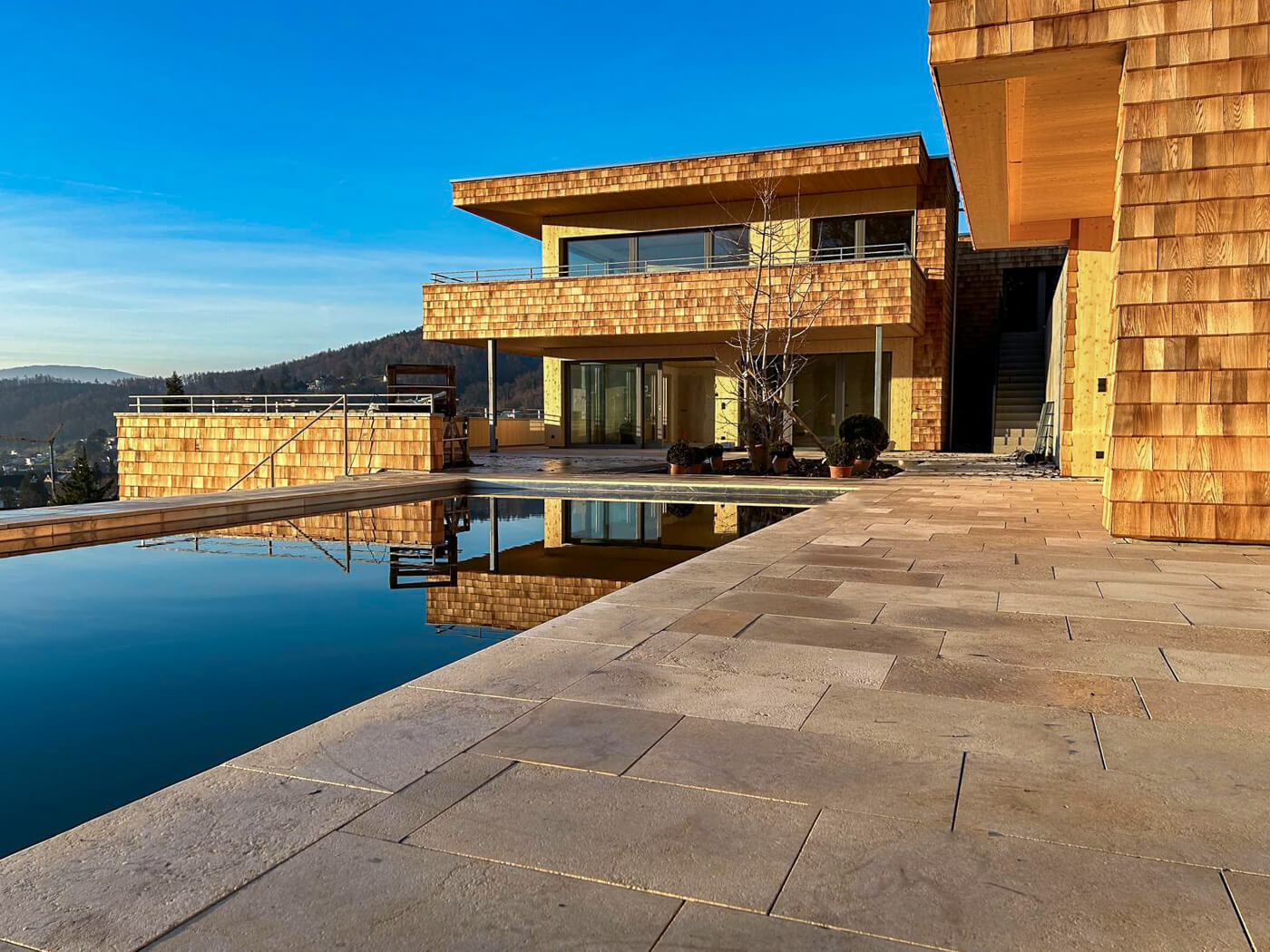 Hausfassade mit Holzschindeln aus Rot Zeder gesgaegt