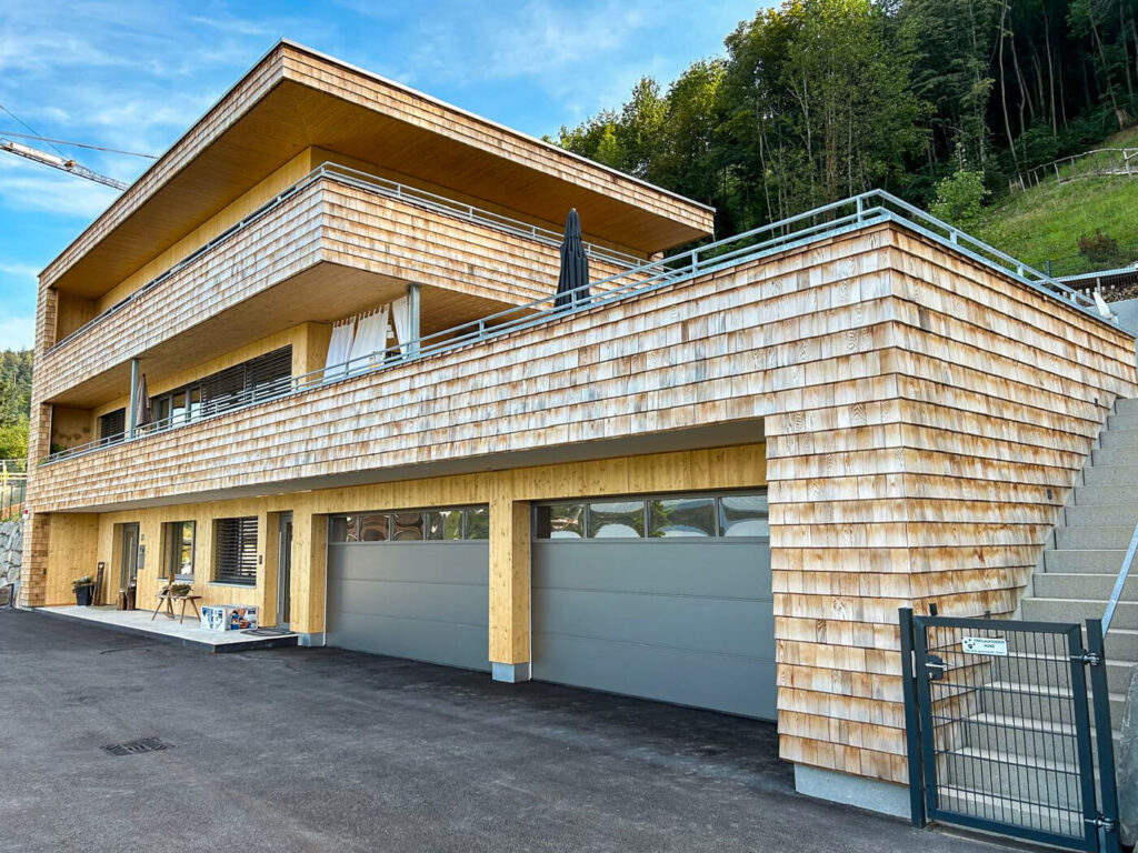Hausfassade mit Holzschindeln aus Rot Zeder gesgaegt